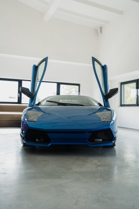 Mėlynas Lamborghini Murcielago su pakeltomis durimis